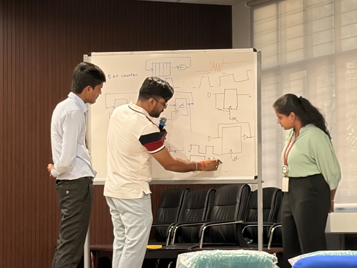 Participants working through a counter and flip-flop timing problem at the whiteboard