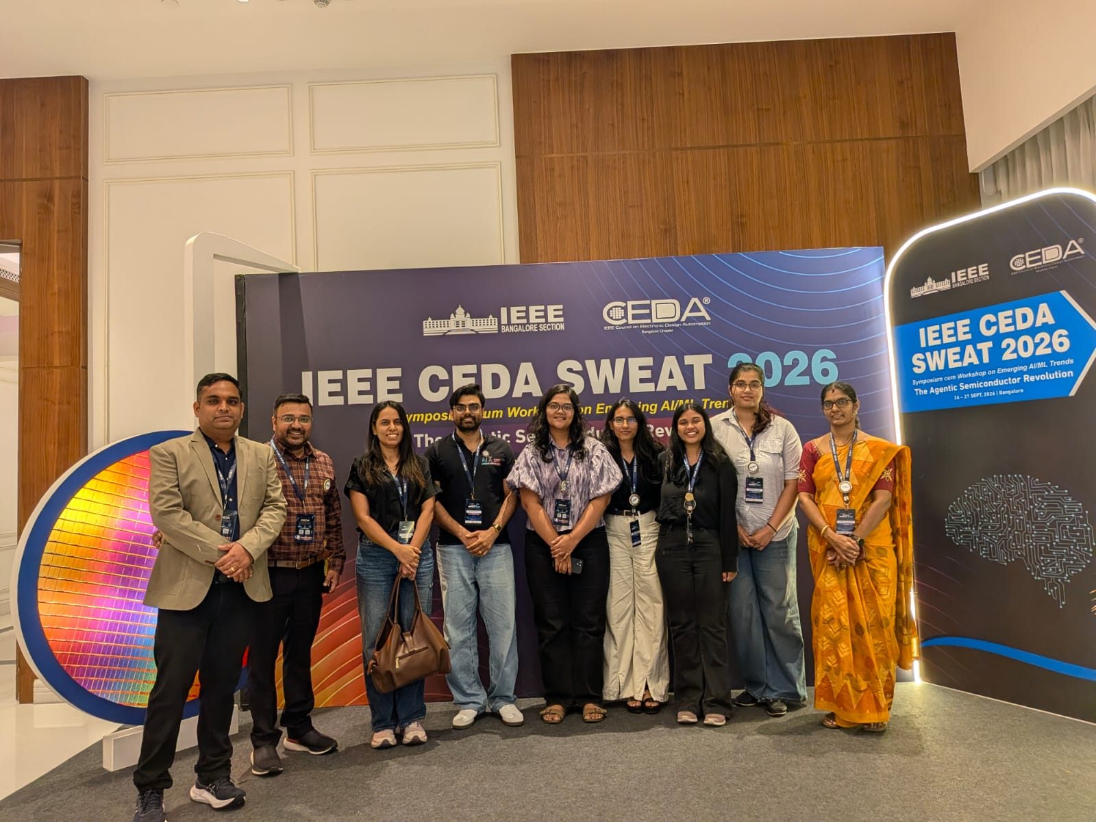 Group photo at the IEEE CEDA SWEAT 2026 backdrop with the silicon wafer display